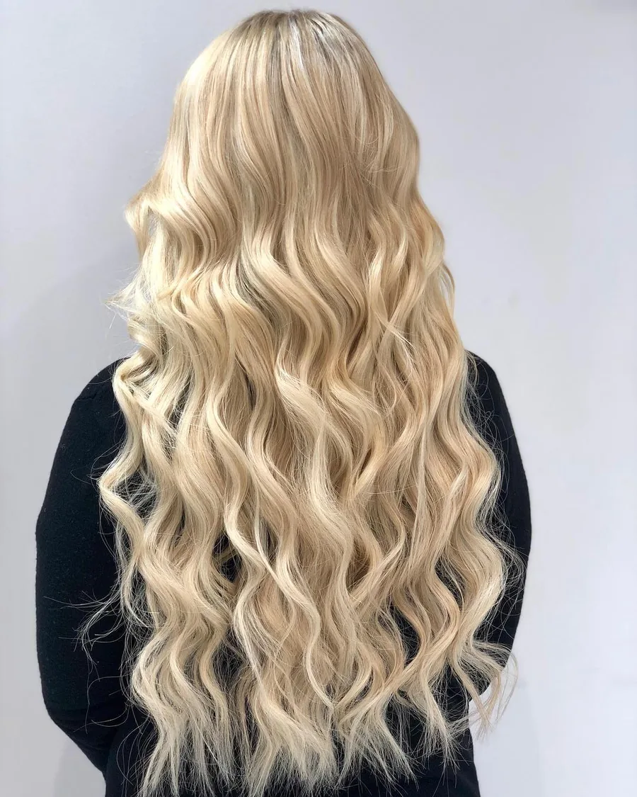 Full back view of long blonde extensions at Monaco, showing soft waves and the finished ends